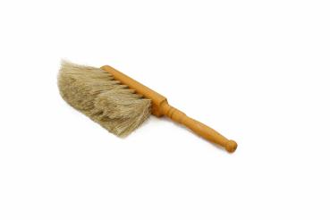 Tischhandfeger mit hellem Ziegenhaar-Besatz, auf der linken Seite liegend.